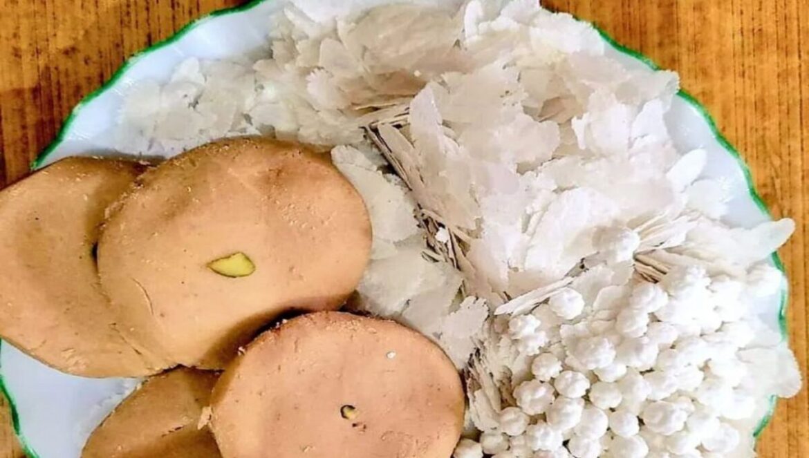 Devotees at Deoghar Shravani Mela 2025 with prasadam items like chura, pedha, and elaichi